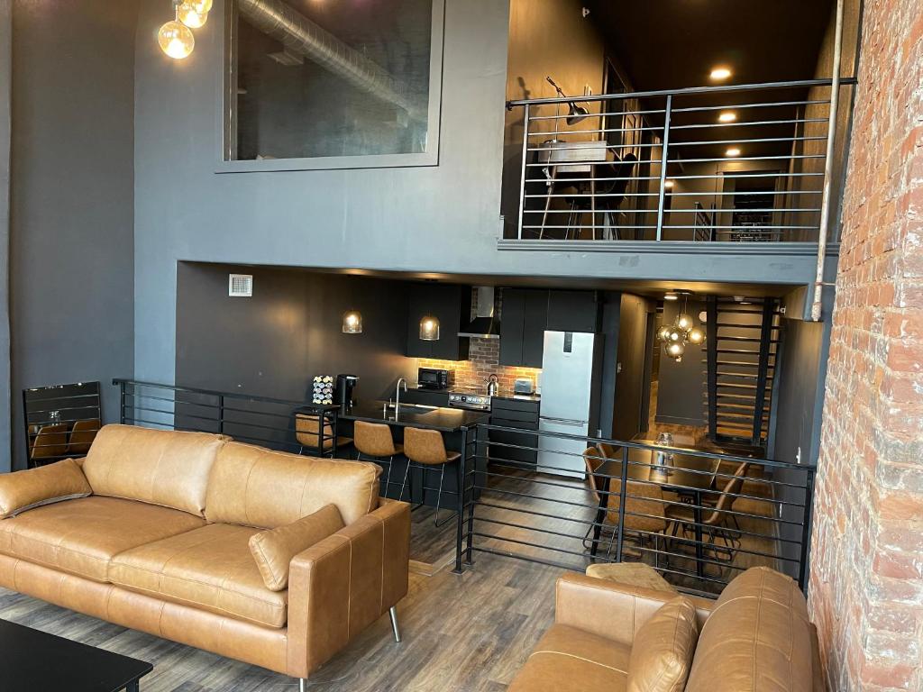 a living room with a couch and a bar at DerbyCity Plush Loft Gather in Style by Hollyhock in Louisville
