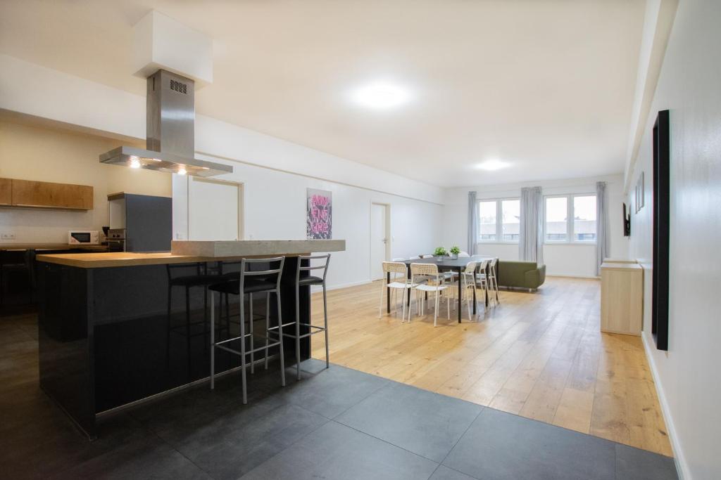 a kitchen and living room with a counter and chairs at RAJ Living - 250m2 Loft with 6 Rooms im Industriegebiet - 20 Min Messe DUS & Old Town DUS in Düsseldorf