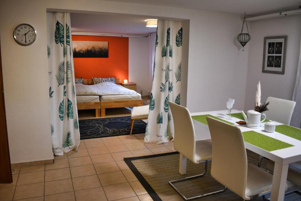 un soggiorno con tavolo e sedie e una camera da letto di Apartment Souterrain Bühl Vimbuch Familie Bork a Bühl