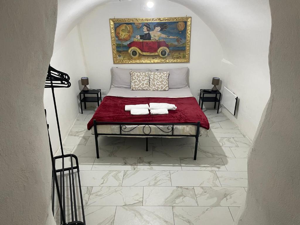 een kamer met een bed met een schilderij aan de muur bij Mory&Clary Cave Palese Airport in Bari Palese