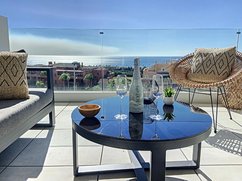 un tavolo con bicchieri e bottiglie di vino sul balcone di Via Celere 2331 Luxury Sea View Apartment a Bahia de Casares