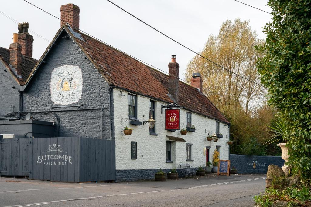 un edificio blanco con un cartel en el costado en The Ring 'O' Bells, en Compton Martin