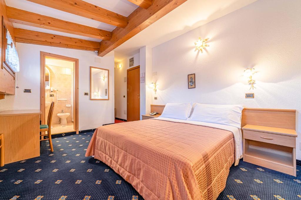Pokój hotelowy z łóżkiem i łazienką w obiekcie Pineta Pastry Hotel w mieście Rocca Pietore