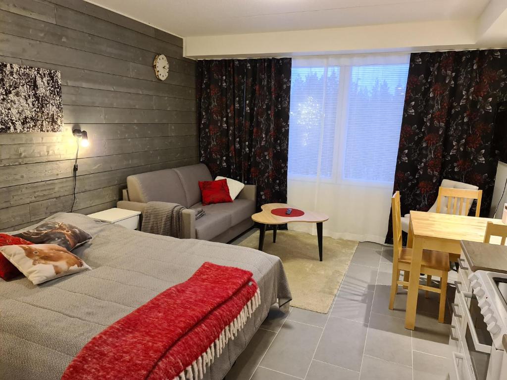 - une chambre avec un lit, un canapé et une table dans l'établissement LeviBooking Lost in Levi apt 305, à Kittilä