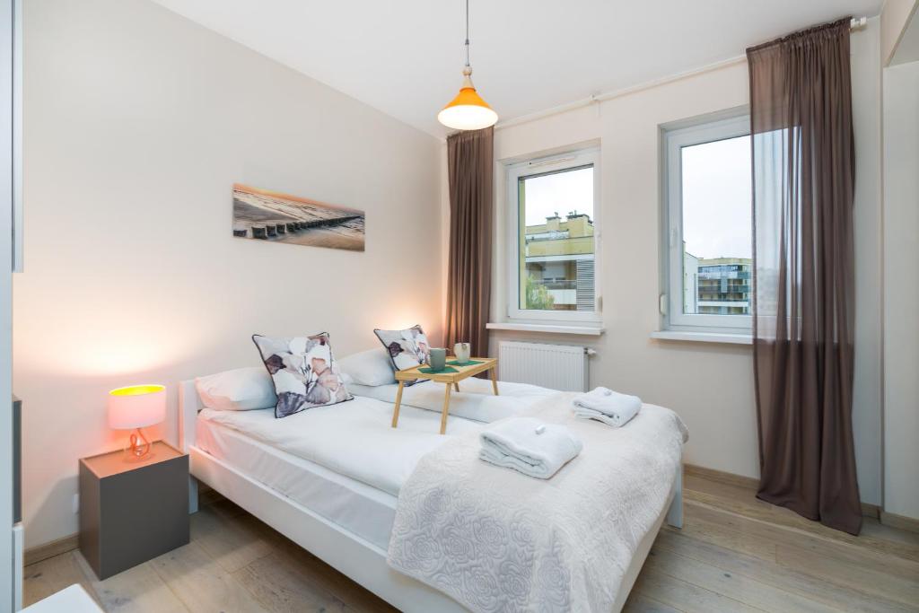 1 dormitorio con 2 camas y ventana en Marcelin Estate Apartments by Renters, en Poznan