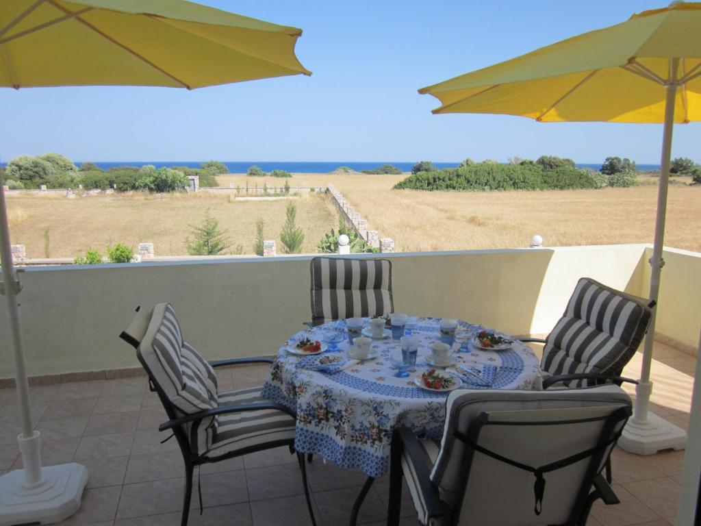 a table with chairs and an umbrella on a patio at Sunshine Villa in Gennadi
