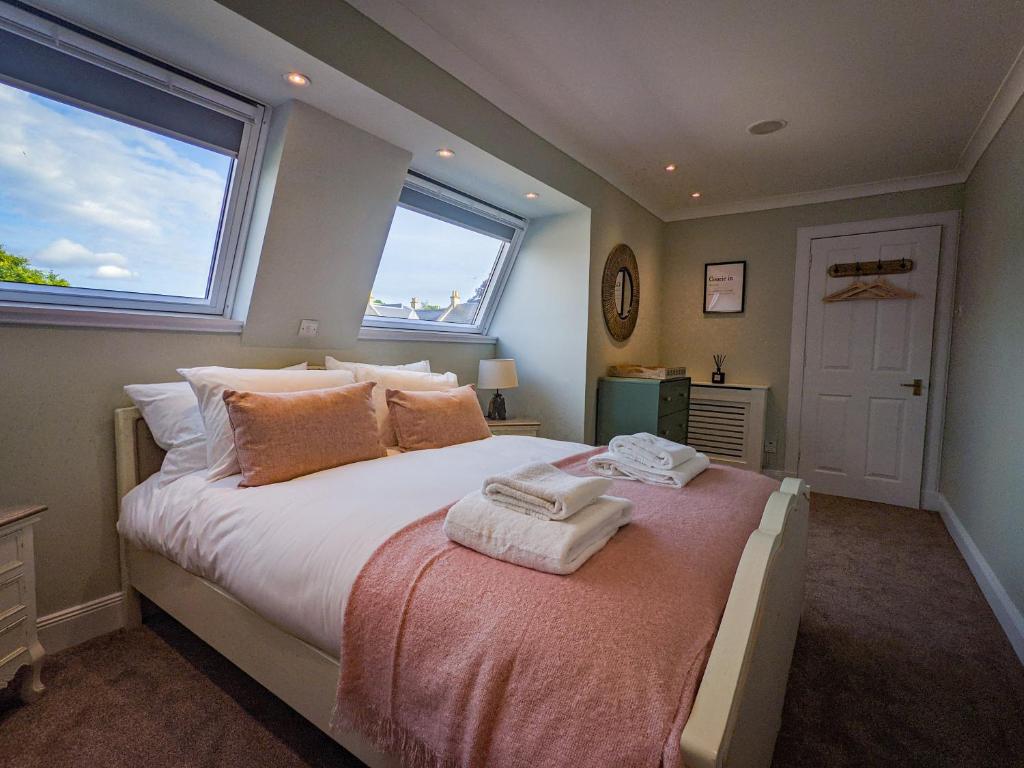 1 dormitorio con 1 cama grande y toallas. en Beautiful Spacious Central Flat, Pitlochry, en Pitlochry
