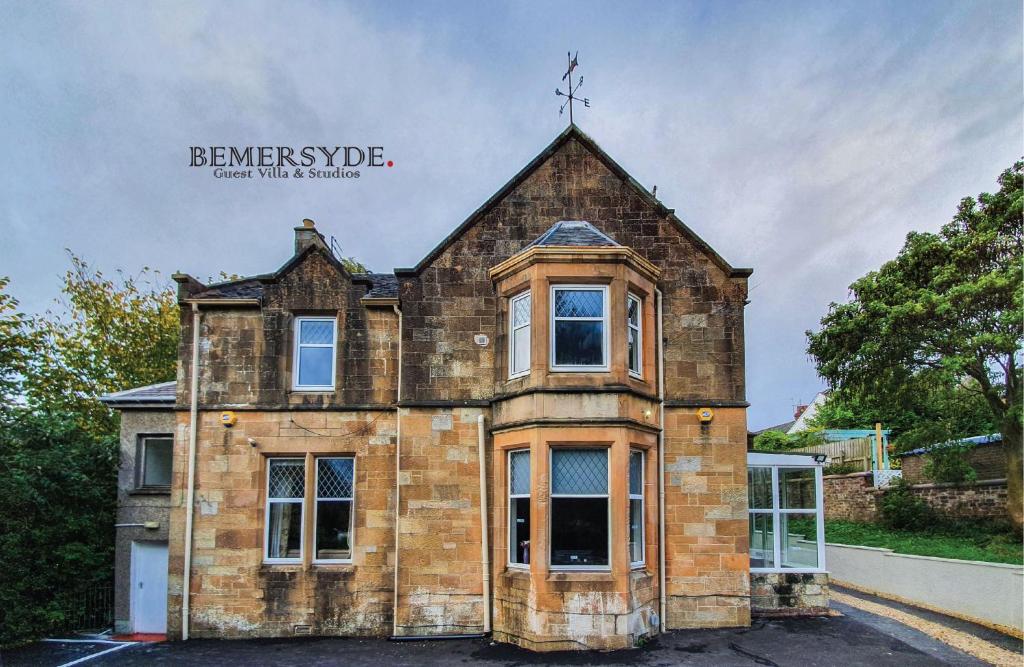 a brick house with a cross on top of it at Bemersyde Villa-Studios in Mansewood