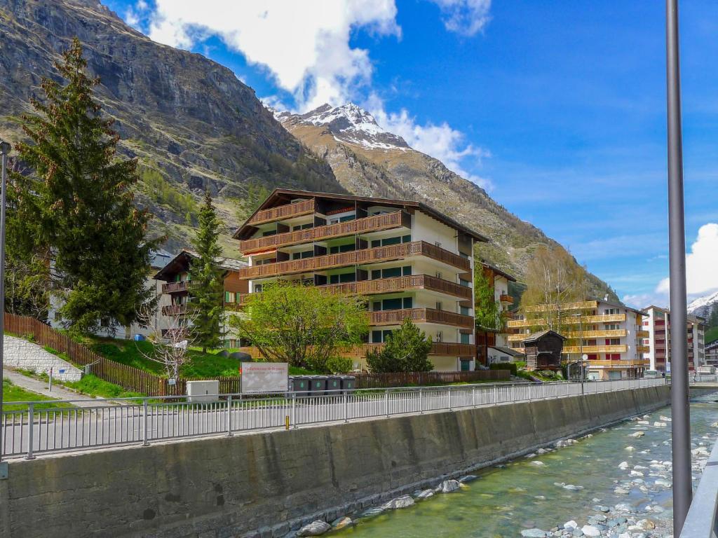 een gebouw naast een rivier voor een berg bij Apartment Matten - Utoring-19 by Interhome in Zermatt
