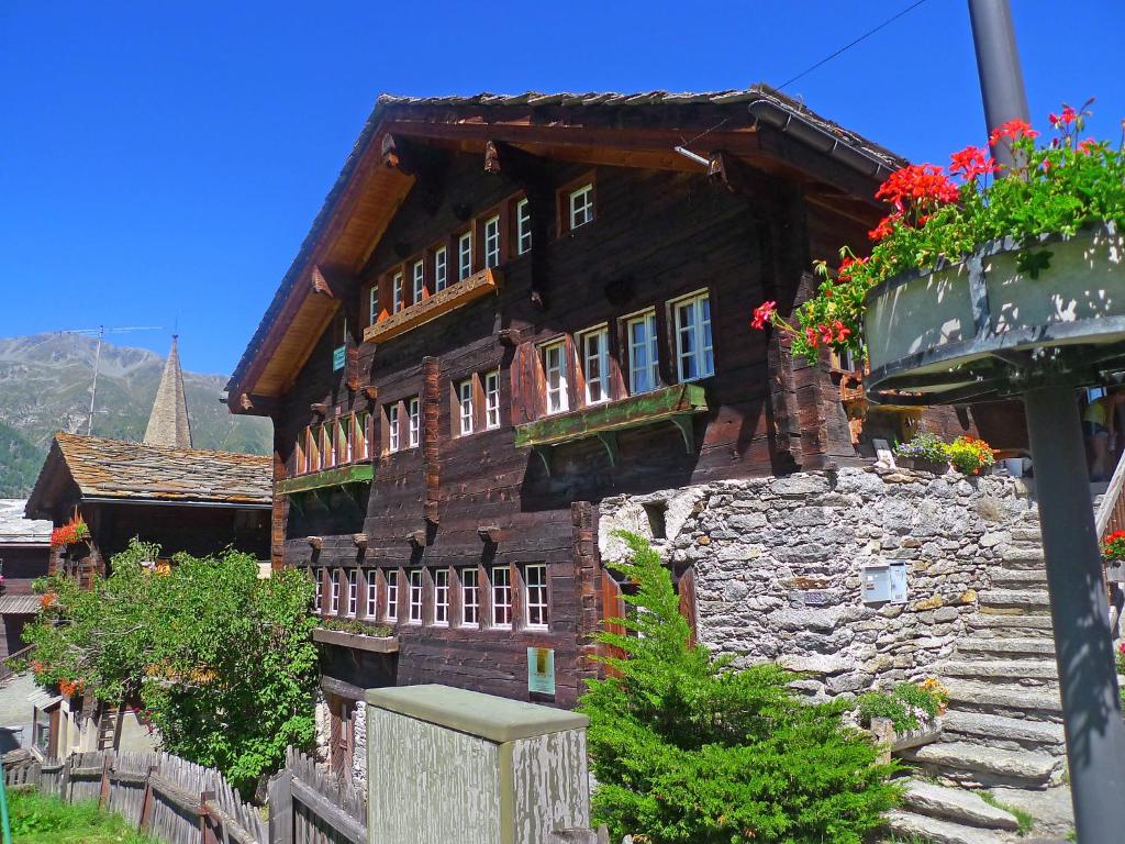 an old building with flowers on the side of it at Apartment Museum by Interhome in Grächen