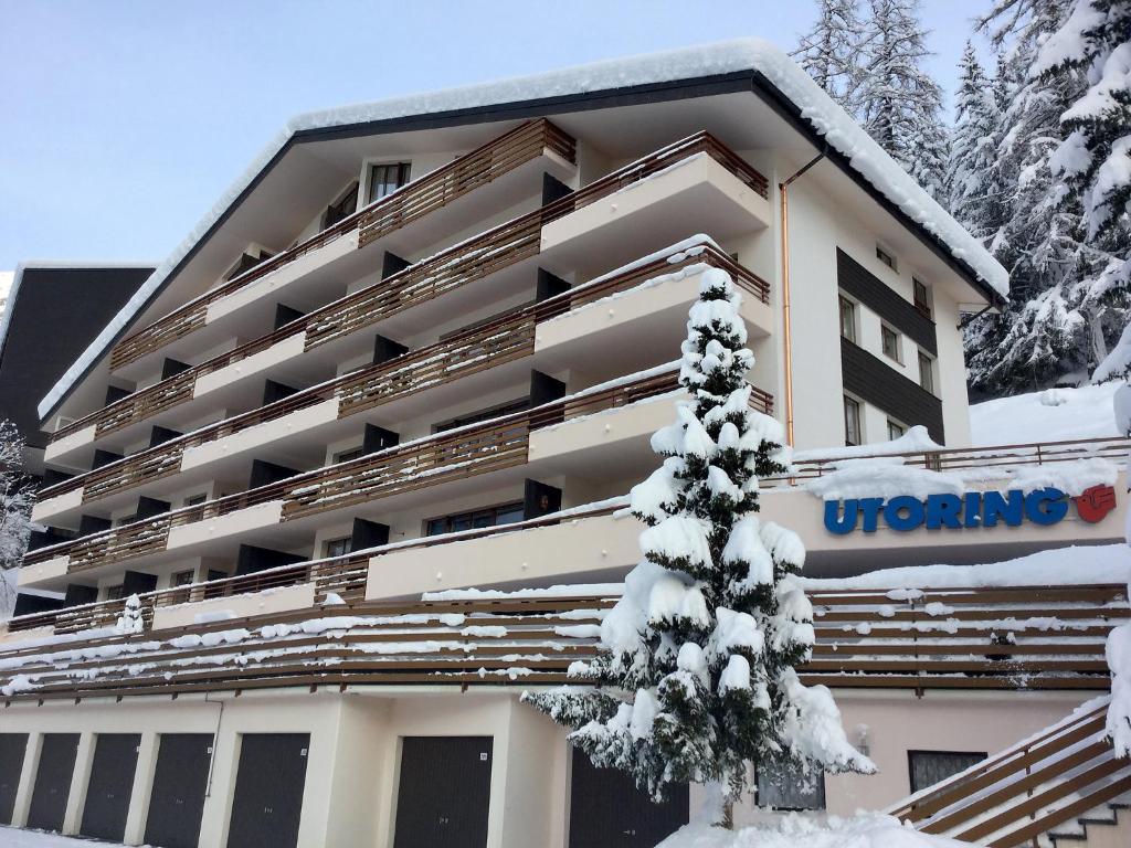 a hotel in the snow with a tree in front of it at Apartment Ringstrasse - Utoring-14 by Interhome in Leukerbad