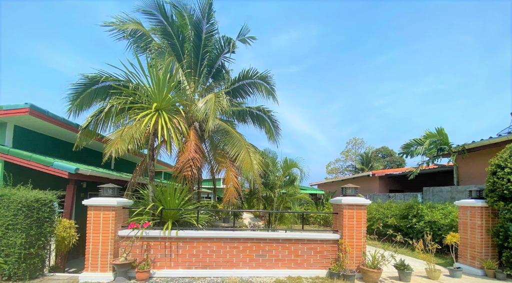 a palm tree in front of a house at Suntalee House in Nai Yang Beach