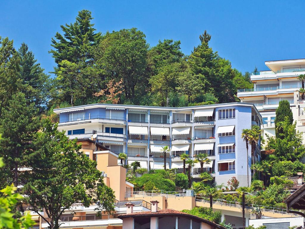 an apartment building on a hill with trees at Apartment Suite Classic-14 by Interhome in Ascona