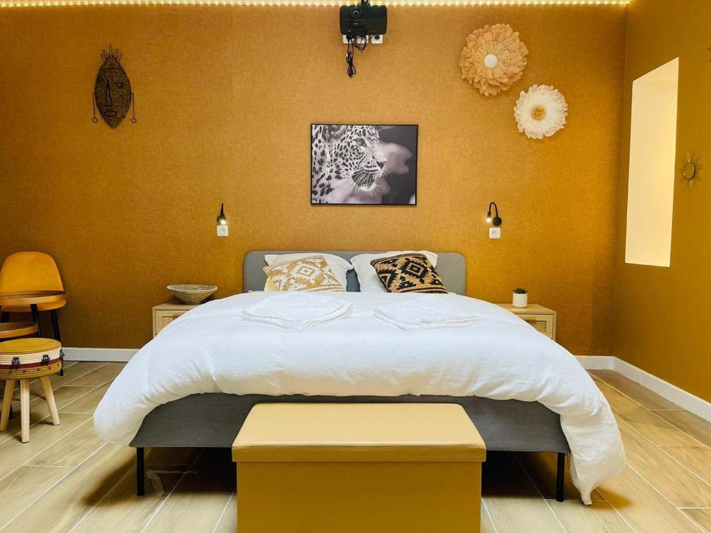 een slaapkamer met een groot bed met gele muren bij NG SuiteHome - Lille I Roubaix I Gare I Métro Alsace - Grand T2 - Balnéo - Netflix - Wifi - Cuisine in Roubaix