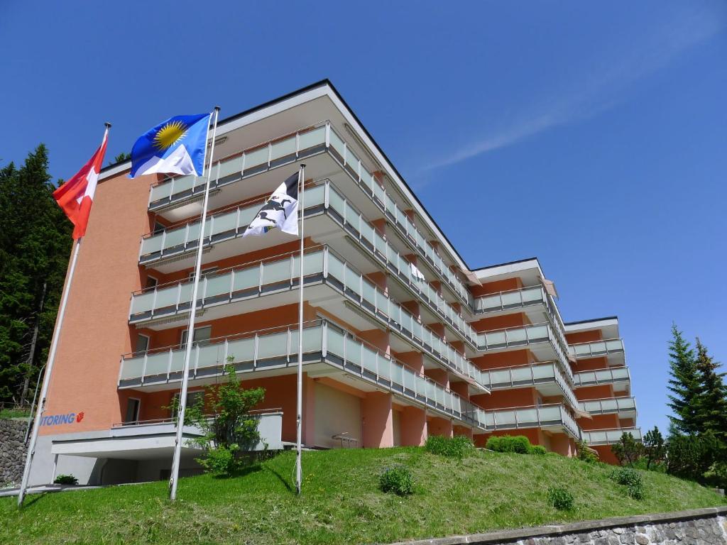 a building with flags in front of it at Apartment Promenade - Utoring-11 by Interhome in Arosa