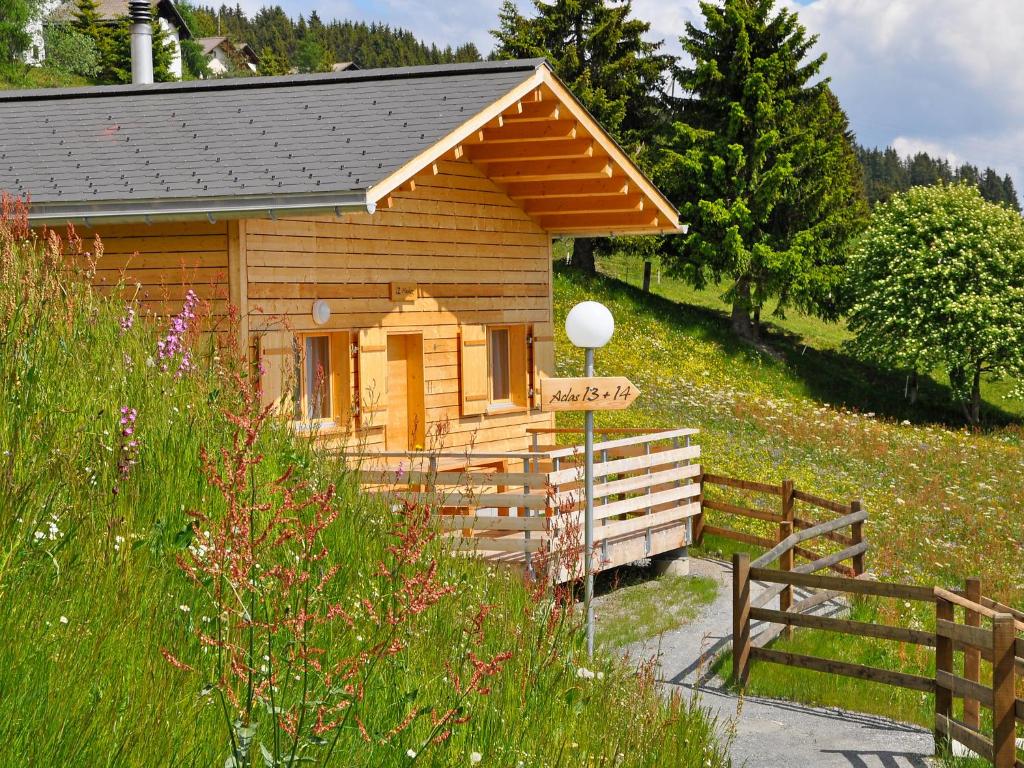 eine kleine Holzhütte auf einem Feld mit einem Zaun in der Unterkunft Holiday Home Komfort Aclas Maiensäss Resort-1 by Interhome in Urmein