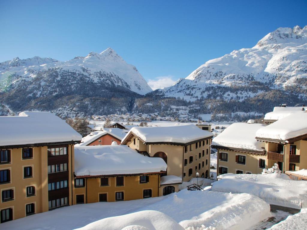 a city covered in snow with mountains in the background at Apartment Residenza Chesa Margun 78-4 by Interhome in Surlej