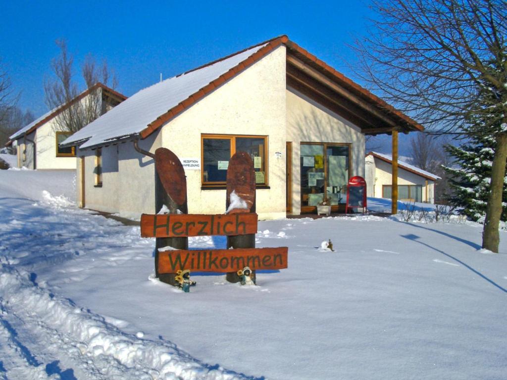 un cartel en la nieve frente a una casa en Holiday Home Solling by Interhome, en Uslar