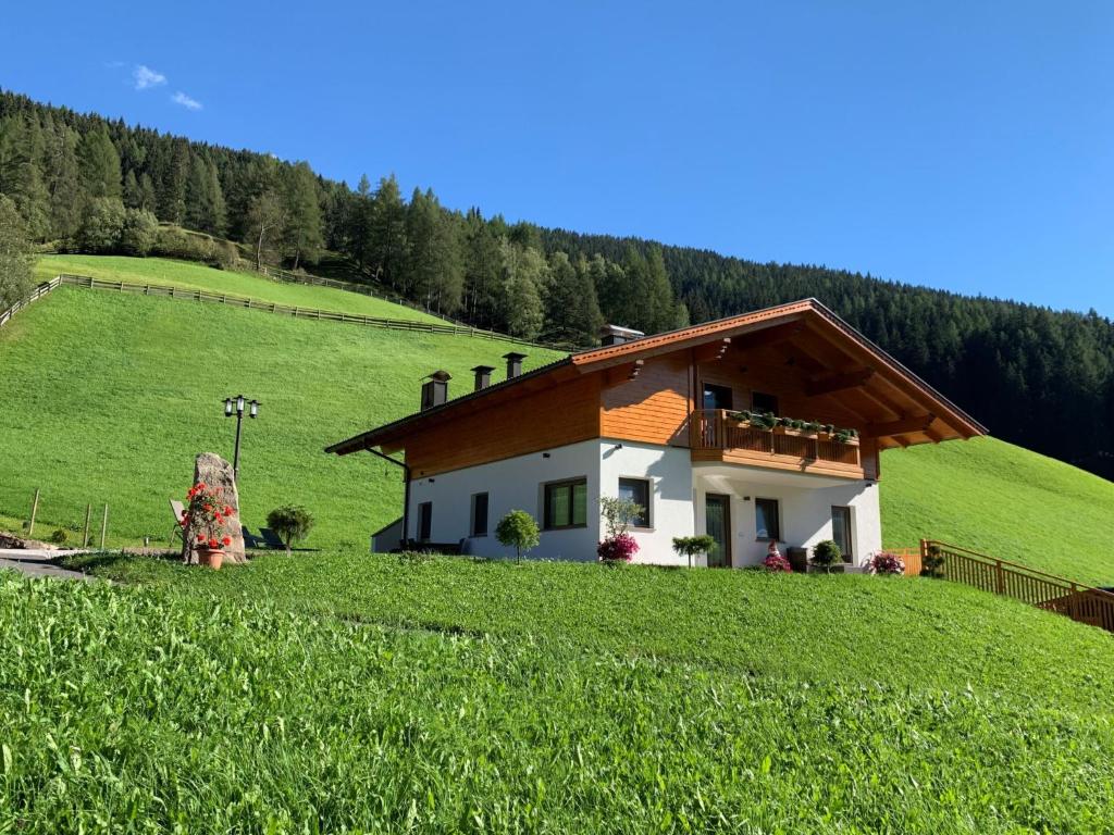 ein Haus auf einem Hügel auf einem grünen Feld in der Unterkunft Holiday Home Spieglhof-4 by Interhome in Sarntal