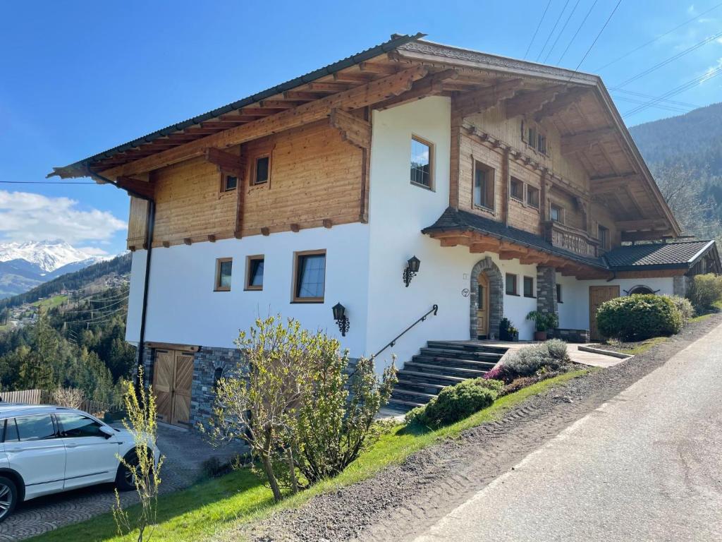 a house in the mountains with a car parked in front at Apartment Häuser by Interhome in Ried im Zillertal