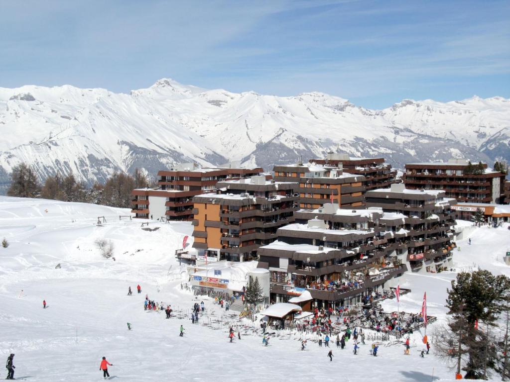 a group of people in the snow in front of a ski lodge at Apartment Zinal 201 by Interhome in Les Collons