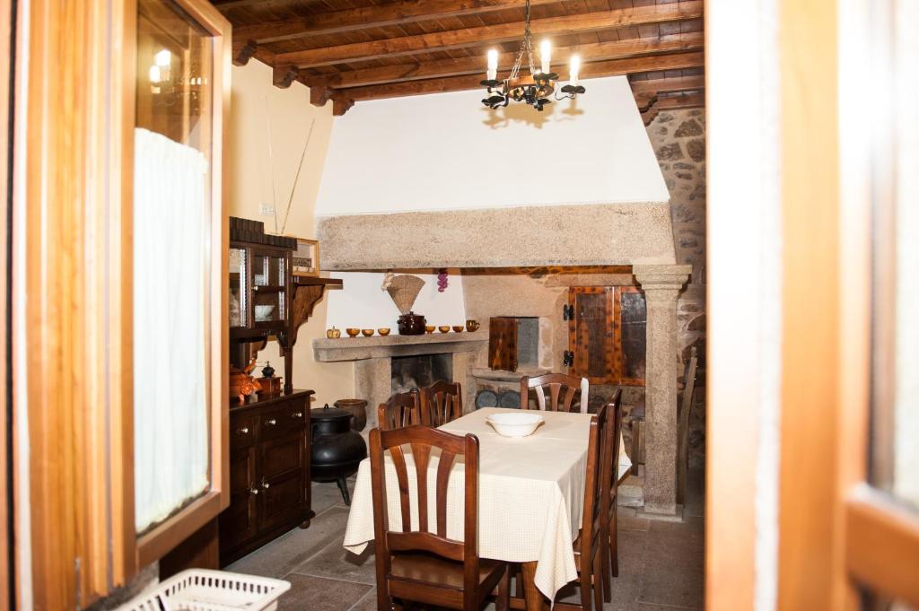 jadalnia ze stołem i kominkiem w obiekcie Casa da Roisa w mieście Rois