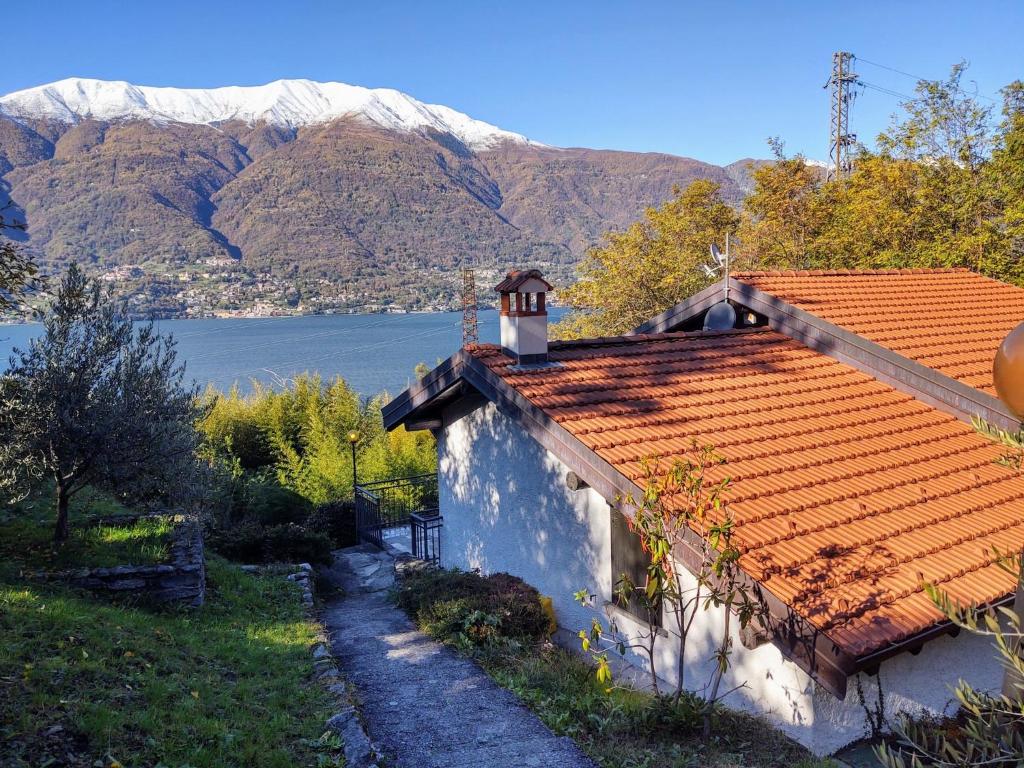 una casa con techo naranja con montañas al fondo en Holiday Home Annita by Interhome, en Dervio