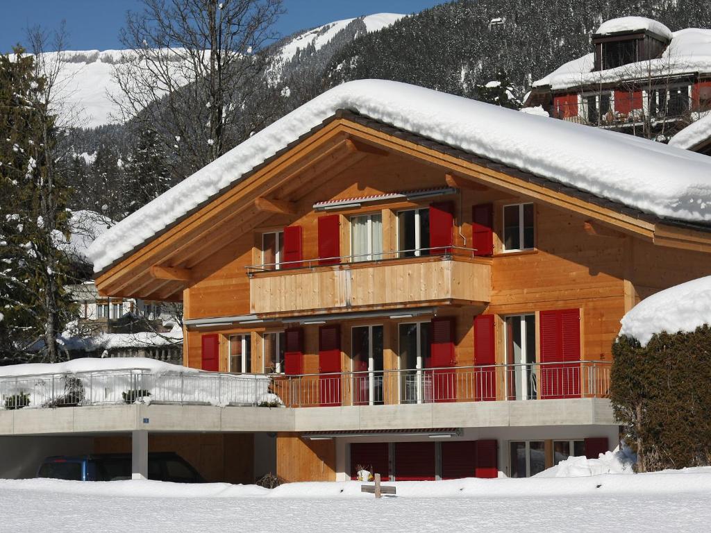 a building with snow on the roof of it at Apartment Chalet Almisgässli by Interhome in Grindelwald
