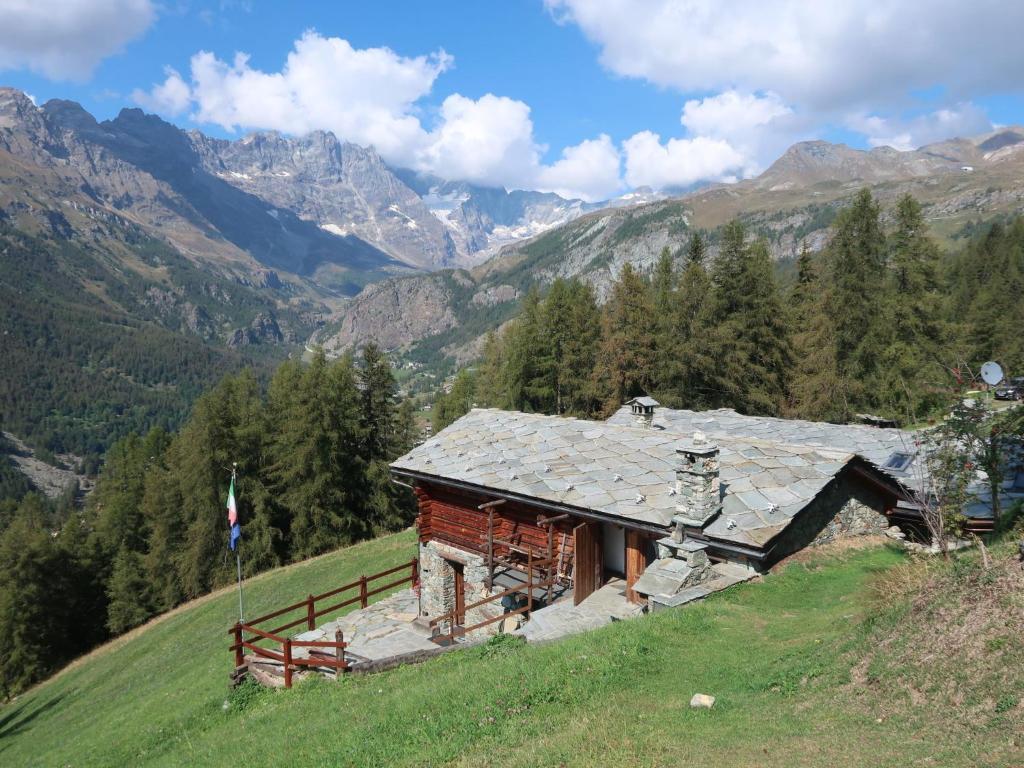 a house on a hill with mountains in the background at Studio Ancienne Bergerie Studio 2 - VOU141 by Interhome in Valtournenche