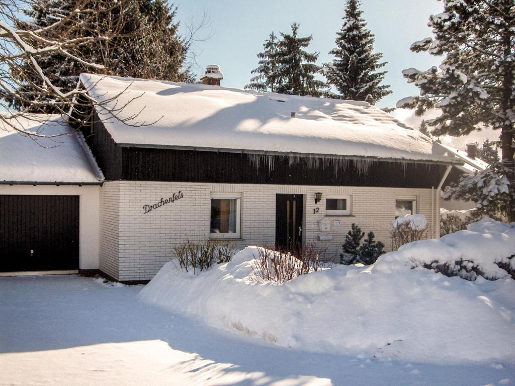 ein Haus mit Schnee auf dem Dach und einer Garage in der Unterkunft Holiday Home Drachenfels by Interhome in Dittishausen