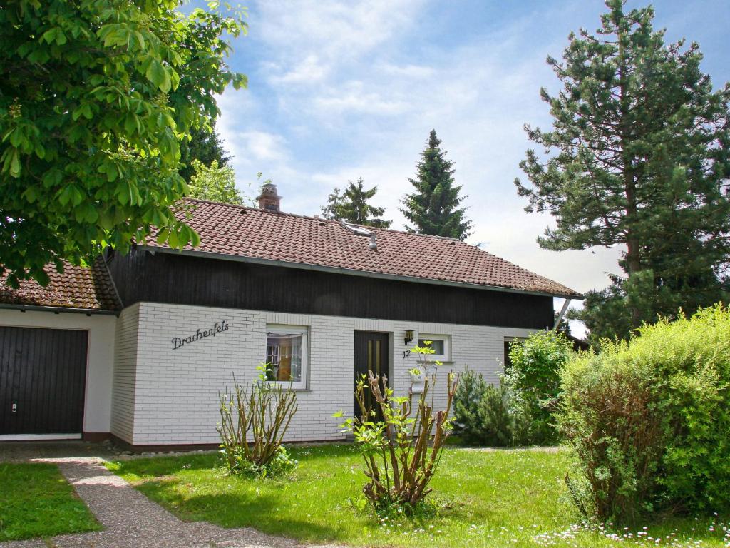 una pequeña casa blanca con un garaje en un patio en Holiday Home Drachenfels by Interhome, en Dittishausen
