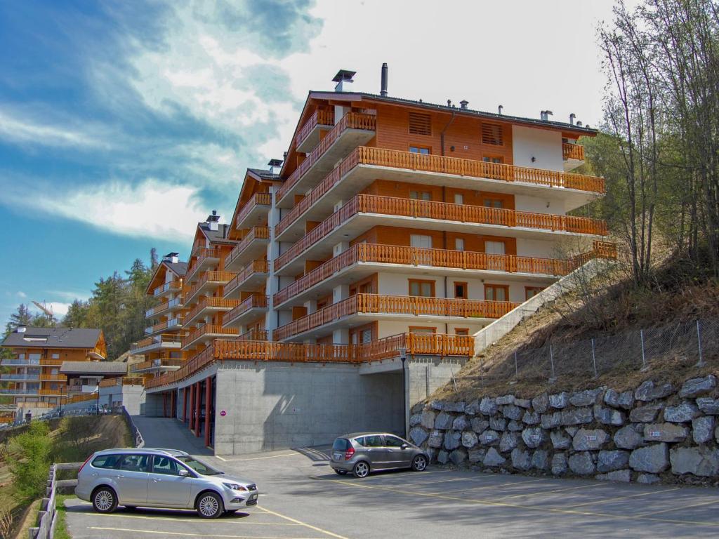 two cars parked in front of a large building at Apartment Grand Panorama C5 by Interhome in Nendaz