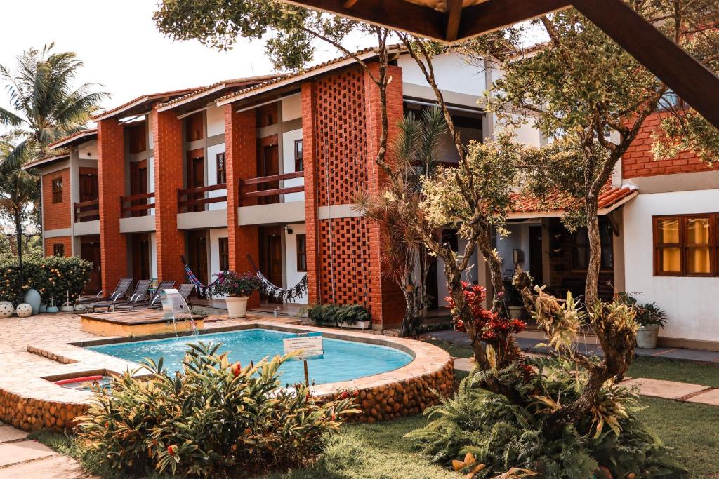 um resort com uma piscina em frente a um edifício em Pousada Porto Paraiso em Porto Seguro