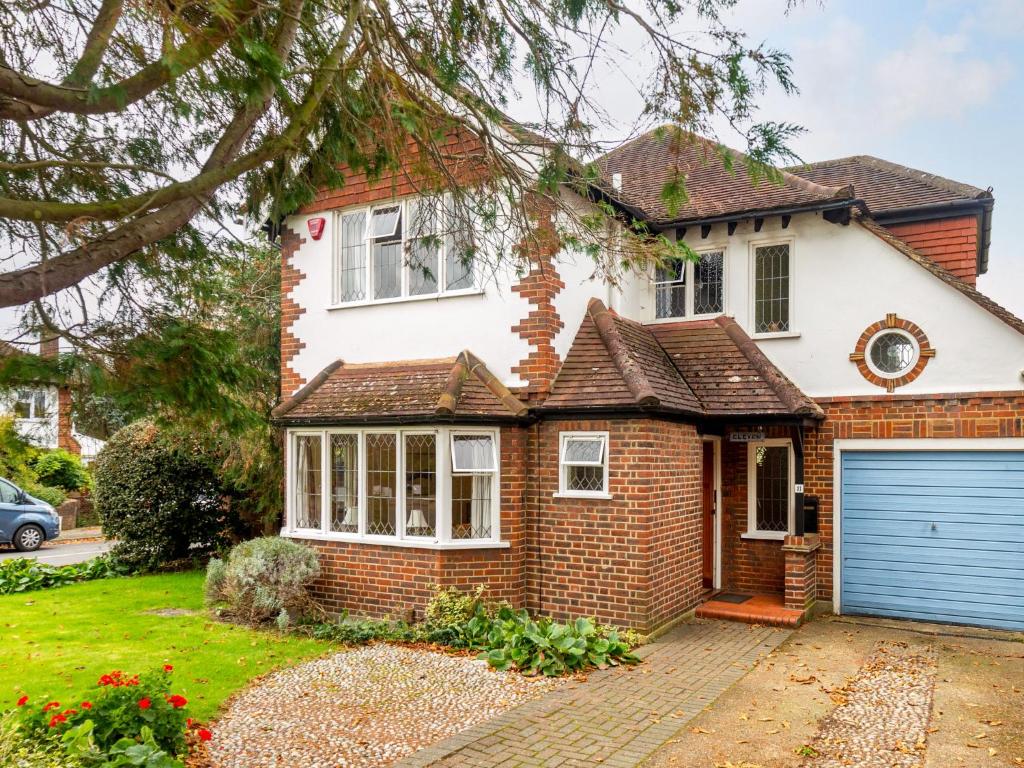 a brick house with a blue garage door at Holiday Home Jeanettes by Interhome in New Malden