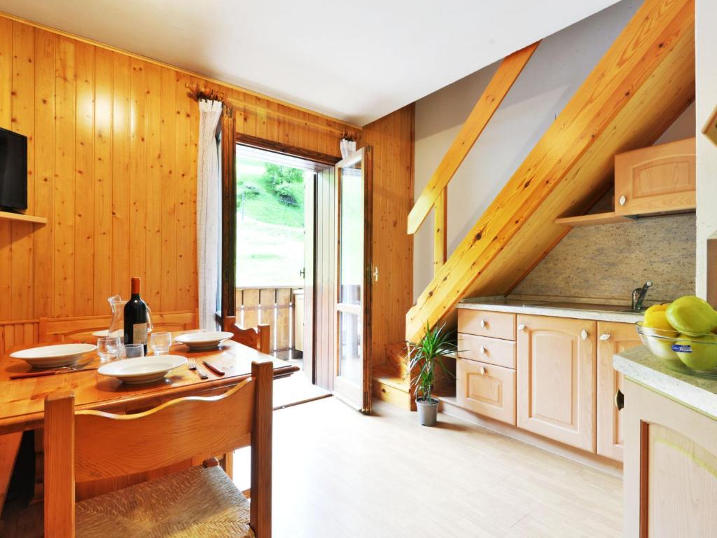 eine Küche mit Holzwänden und einem Holztisch im Zimmer in der Unterkunft Apartment Penia 2-1 by Interhome in Penia