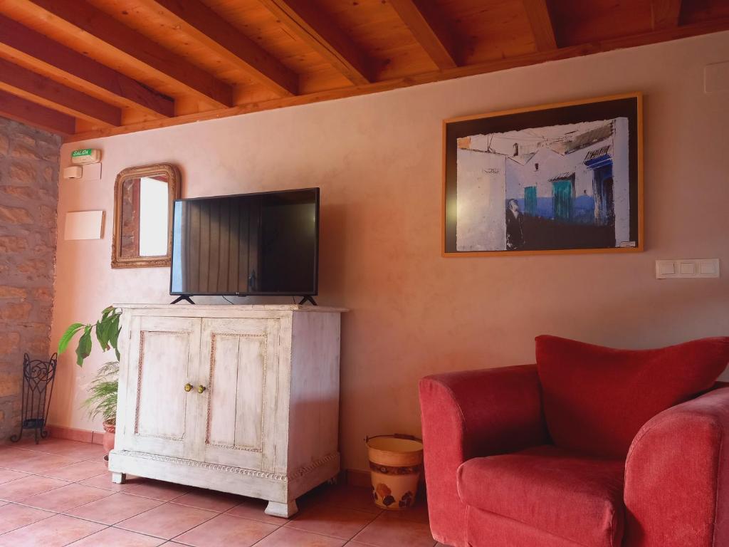 ein Wohnzimmer mit einem TV und einer roten Couch in der Unterkunft Errotazar apartamento rural P in Alsasua