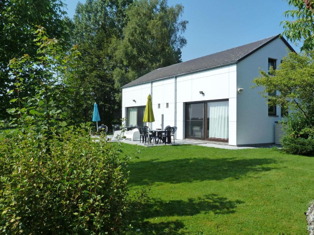 ビュートゲンバッハにあるHoliday Home Au bord du Lac-2 by Interhomeの芝生の庭のある白い家