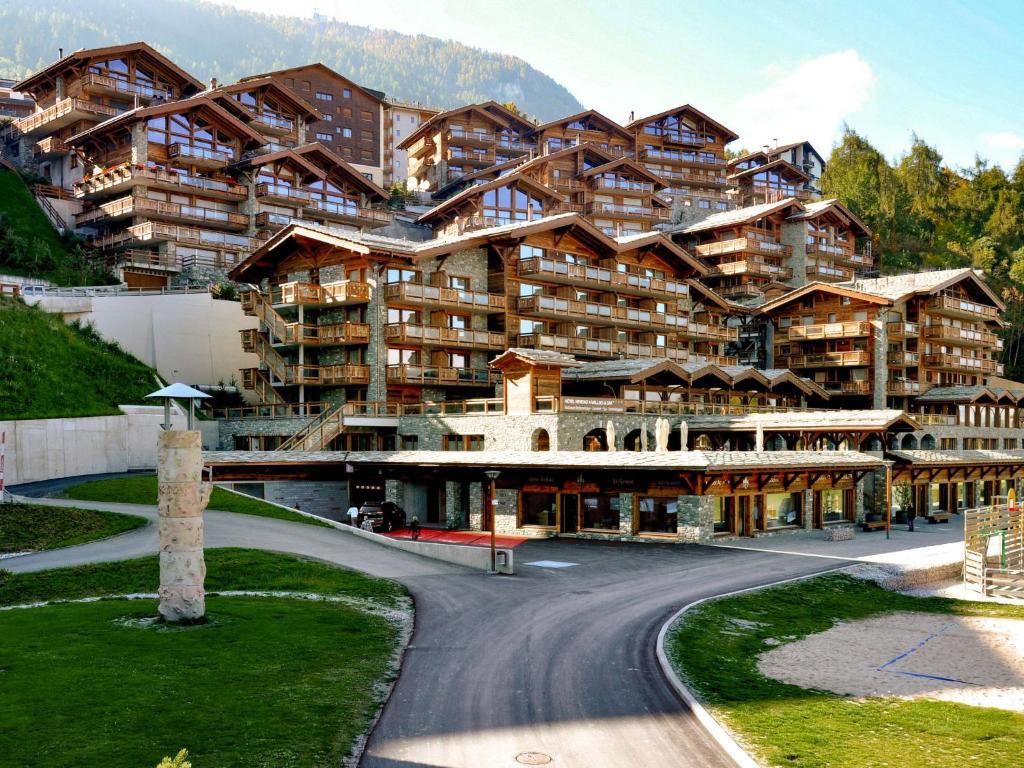 a large apartment building with a road in front of it at Apartment Le Refuge 1 by Interhome in Nendaz