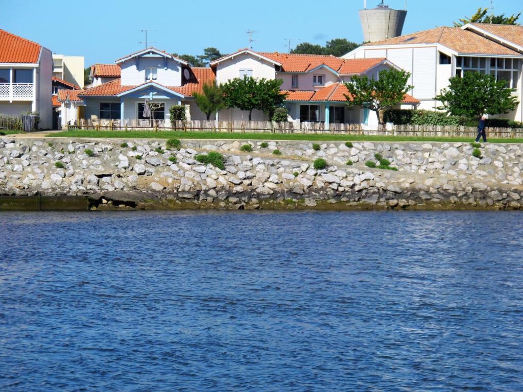 a group of houses next to a body of water at Holiday Home Le Hameau des Pêcheurs 5-1 by Interhome in Mimizan-Plage