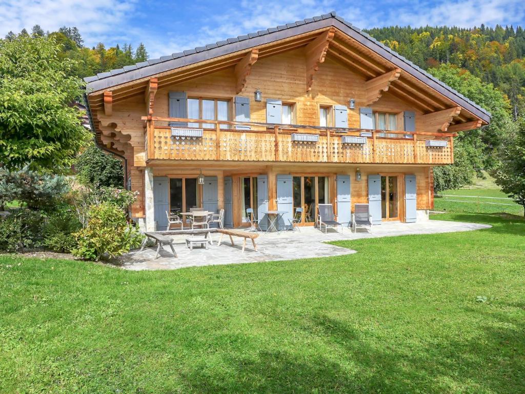 a log house with a table and chairs in a yard at Chalet Les 3 Soeurs by Interhome in Villars-sur-Ollon