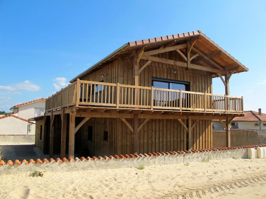 a wooden house with a deck on the beach at Holiday Home Les Mouettes by Interhome in Mimizan-Plage