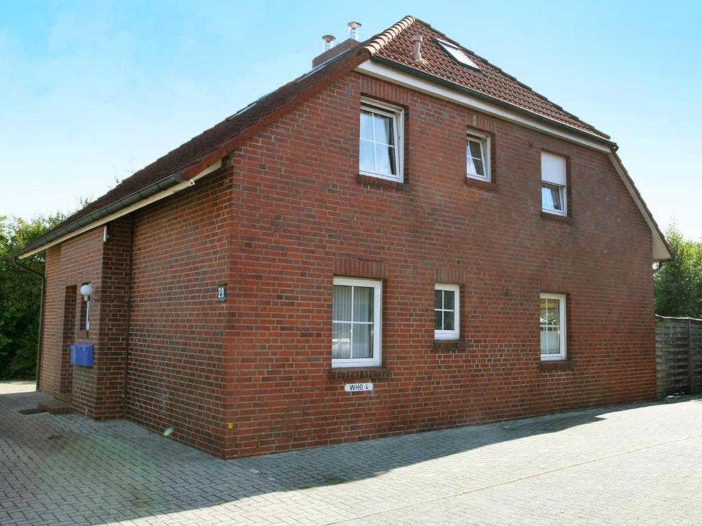 a red brick building with white windows on it at Apartment Seehund by Interhome in Norddeich