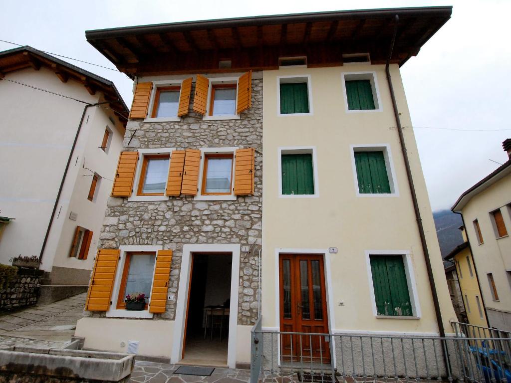 a house with wooden shutters on a building at Holiday Home Albergo Diffuso - Cjasa Ressa by Interhome in Barcis