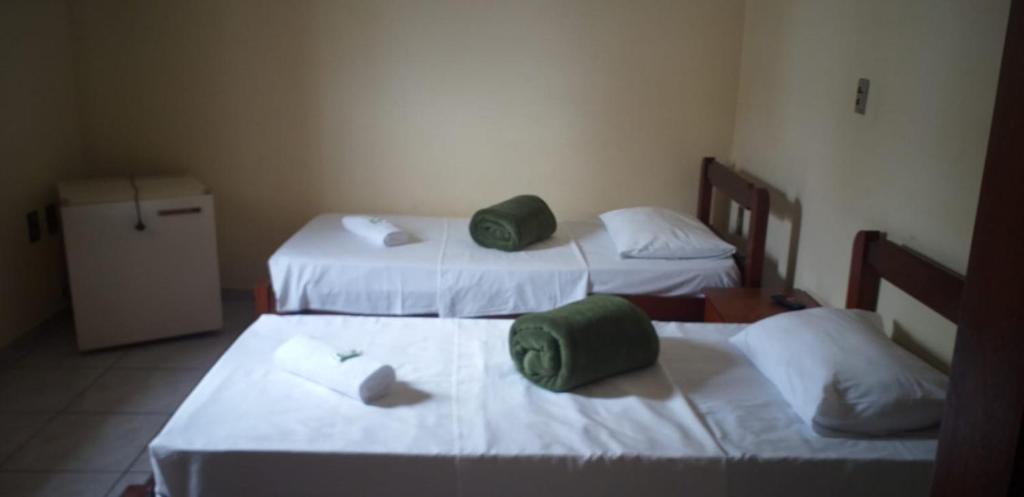 a room with two beds with green towels on them at Hotel Guarini in Monte Sião