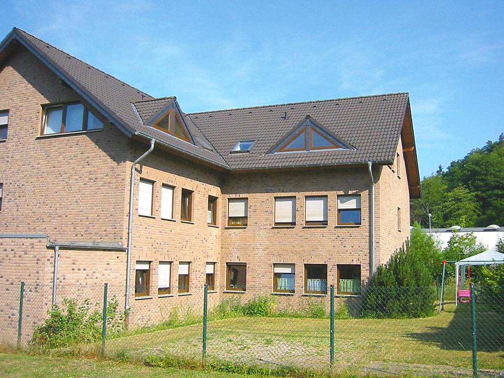 un grand bâtiment en briques avec un toit noir dans l'établissement Apartment Ferienapartments Adenau-2 by Interhome, à Adenau