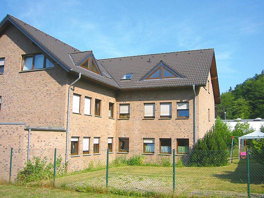 ein großes Backsteingebäude mit schwarzem Dach in der Unterkunft Apartment Ferienapartments Adenau-2 by Interhome in Adenau
