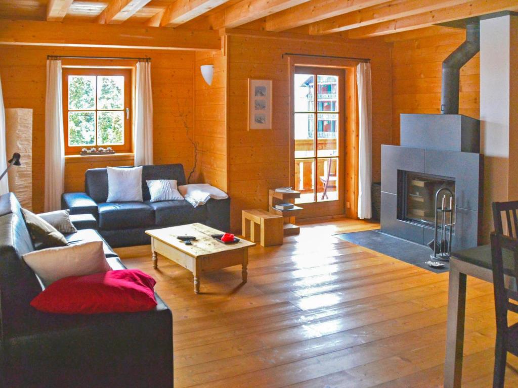 sala de estar con sofá y chimenea en Apartment Alpina by Interhome, en Wengen