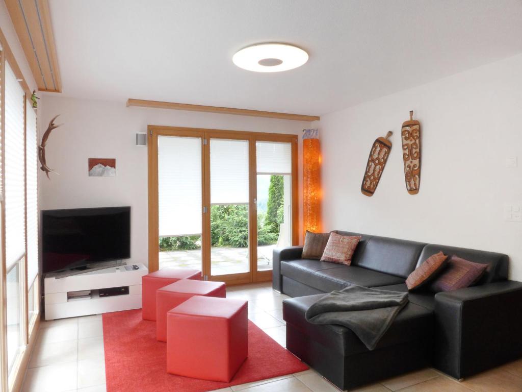 ein Wohnzimmer mit einem Sofa und einem TV in der Unterkunft Apartment Fortuna by Interhome in Wengen