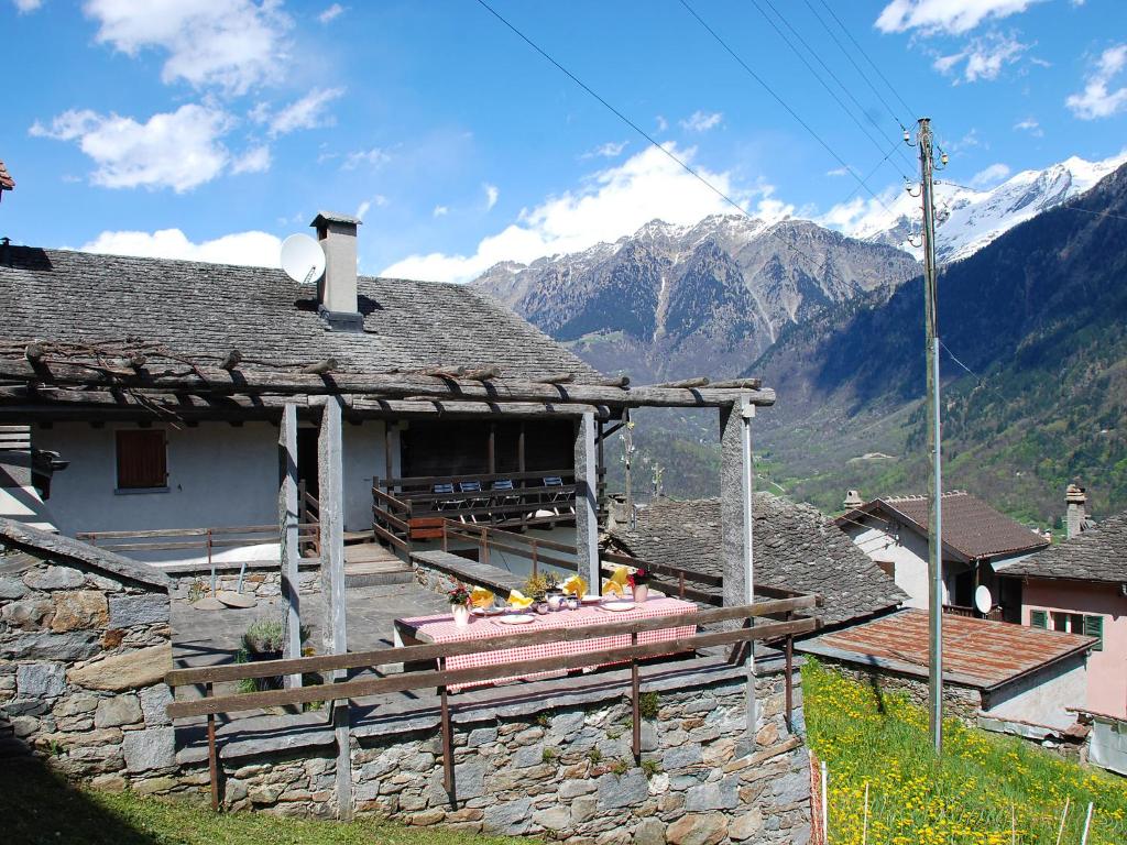 ein Steinhaus mit Bergen im Hintergrund in der Unterkunft Holiday Home Mona by Interhome in Leontica