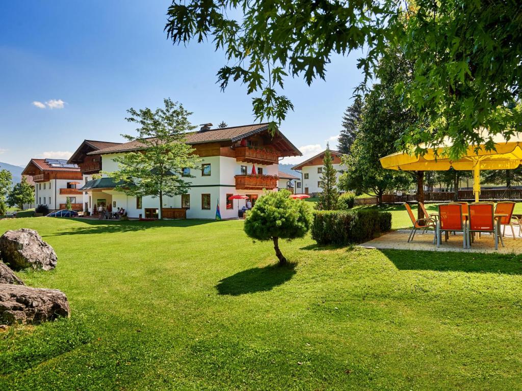 a house with a yard with a table and chairs at Apartment Sonnberg-1 by Interhome in Flachau